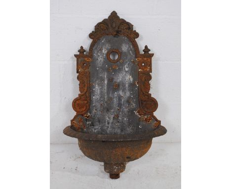 A weathered cast iron garden wall fountain basin