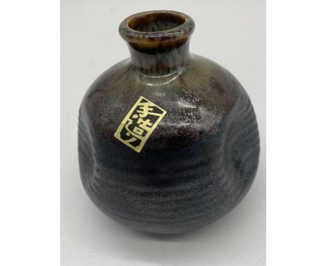 A signed Japanese Tokkuri (Sake Flask) with three indents to the body, original label attached, height 9cm.