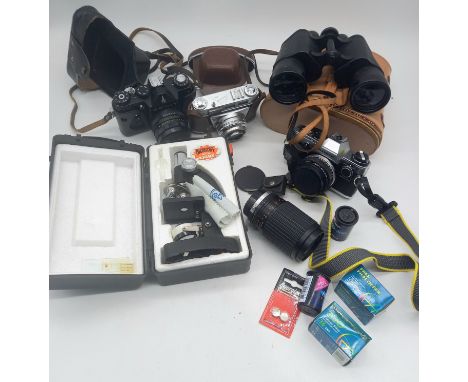 A collection of assorted vintage cameras, to include Zenit, kodak etc, a student microscope, and a pair of binoculars.