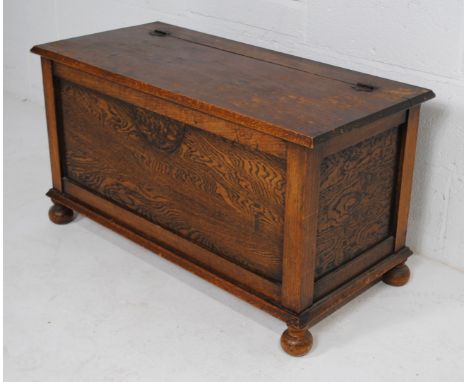 A 20th Century oak trunk, with embellished detailing, raised on ball feet - length 91.5cm, depth 42cm, height 48.5cm