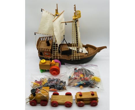 A Playmobil pirate set including ship, figures, cannons, boat, barrel, chest etc, along with a childs wooden toy pull-along t