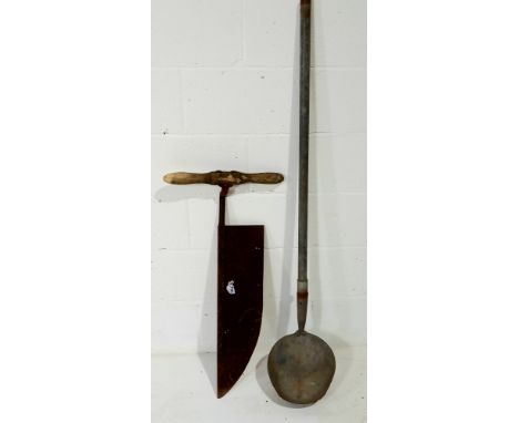 A large vintage scythe and a large ditch ladle.