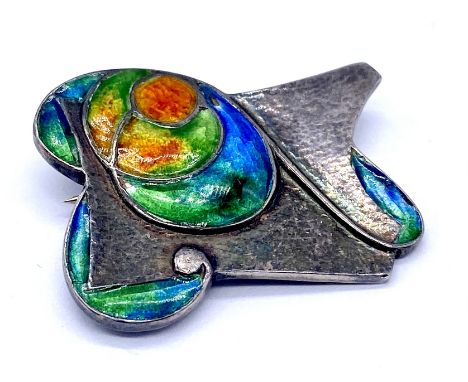 An Archibald Knox designed Arts & Crafts enamelled brooch of hammered silver and stylised plant forms, stamped Silver and VBO