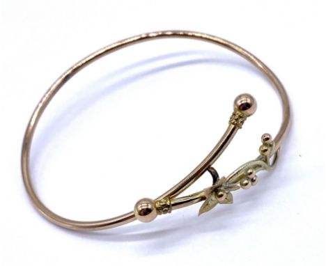 An unmarked 9ct gold bangle with floral decoration, weight 3.6g