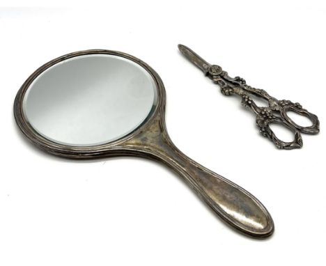 A hallmarked silver hand mirror along with a pair of silver plated grape scissors