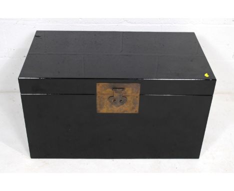 A black lacquered trunk, with brass handles - length 85.5cm, depth 48.5cm, height 48cm