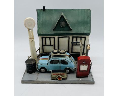 A vintage magnetic children's toy forecourt garage with petrol pump, street lamp, oil drum etc, along with a tinplate car