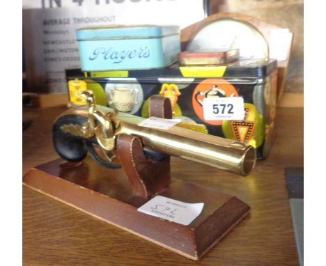 A vintage flintlock pistol pattern table lighter, three tins and a Metamec desk timepiece