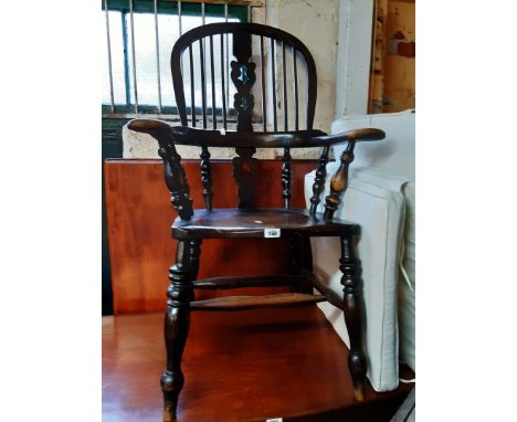 An early 20th Century stained elm and mixed wood Windsor bow elbow chair with high hoop stick back and solid moulded seat, se