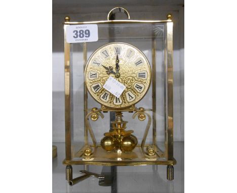 A vintage Kundo brass and bevelled glass cased anniversary clock with sphere pendulum