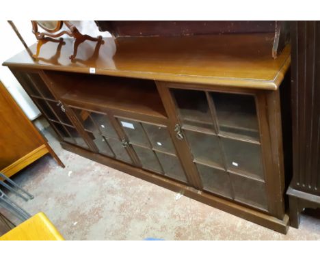 A 1.87m 20th Century stained mixed wood book cabinet with central recessed shelf and two glazed panel doors with further shel