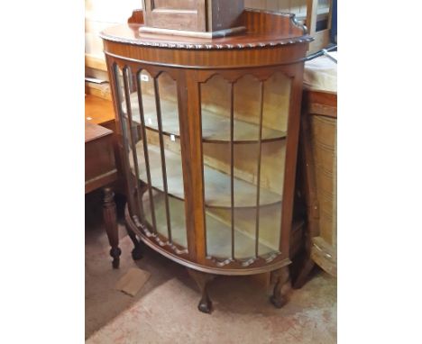 A 108cm 1920's mahogany bow front display cabinet with low raised back and material lined interior enclosed by a beaded glaze