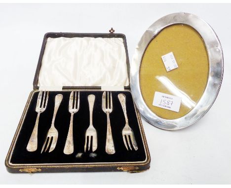 A damaged silver fronted oval photograph frame with wood easel back - sold with a cased set of six silver cake forks - Birmin