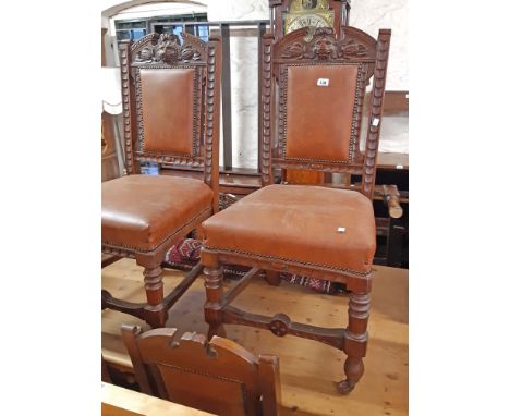 A set of six late Victorian heavy oak framed panel back dining chairs with lion mask decoration to top rails and studded leat
