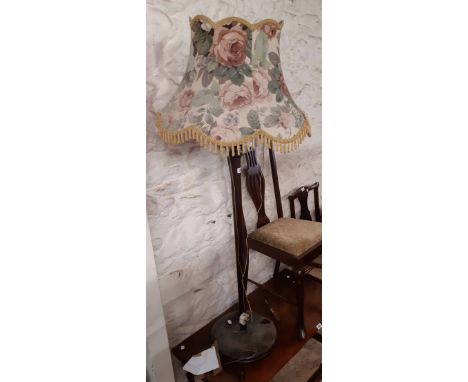A vintage stained wood standard lamp with original shade and circular base