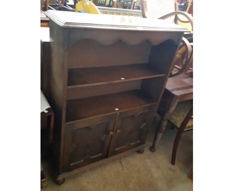 A 91cm 20th Century oak two shelf open bookcase with decorative apron to top and pair of panelled cupboard doors under, set o