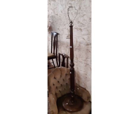 A vintage polished oak standard lamp with turned and fluted pillar set on circular platform base