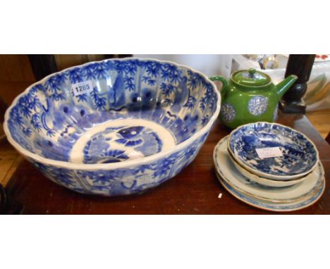 A large Japanese porcelain fluted bowl handpainted in blue with continuous frieze and figures, the central well with yin yang