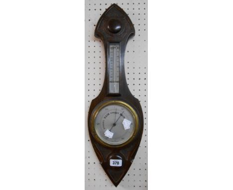 A stained oak Gothic style cased barometer/thermometer with aneroid works