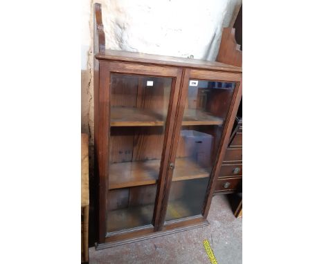 A 67cm late Victorian pitch pine wall mounted three shelf book cabinet enclosed by a pair of glazed panel doors