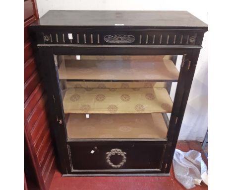 A 76.5cm late Victorian ebonised display cabinet with material lined shelves enclosed by a part glazed panel door - one side 