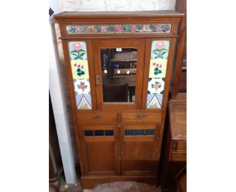 A 90cm early 20th Century walnut cabinet with central mirror panel door, later applied tiling, two central drawers and pair o