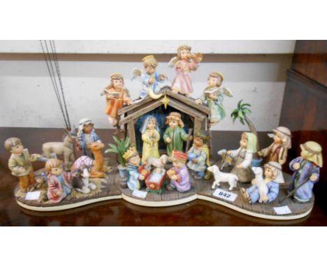 A Danbury Mint MJ Hummel modular Nativity scene comprising Come Let Us Adore Him, Holy Night, Heavenly Choir, and Follow the 