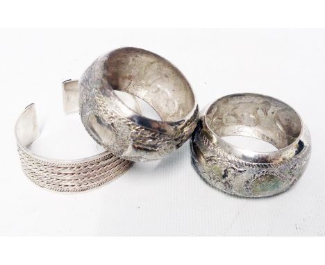 Two Anglo Indian white metal napkin rings with embossed horse and boss decoration - sold with a marked 925 ornate bangle