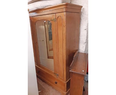 A 1.37m Victorian polished pine wardrobe with rounded moulded cornice and re-hinged arched mirror panel door with long deep d