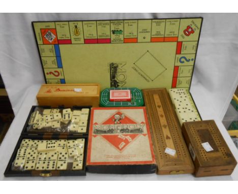 An old Monopoly game with paper playing pieces - sold with assorted games and dominoes, cribbage boards, etc.