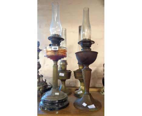 A brass Corinthian column table oil lamp with faceted glass reservoir - sold with a similar brass model and two Aladdin lamps