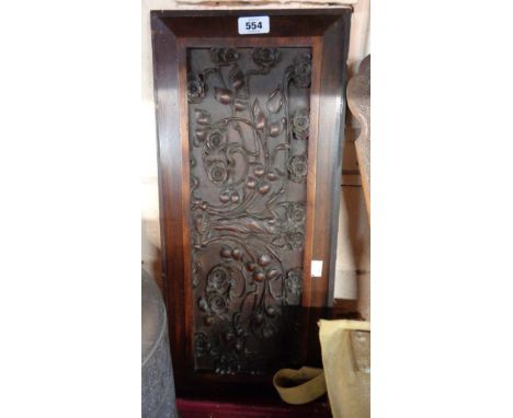 A carved wood panel with an elaborate Art Nouveau design of a maiden with entwined flower heads and leaf whiplash stems