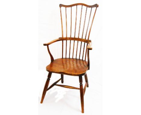 An antique pine stick back Windsor elbow chair with moulded solid elm seat, set on turned supports