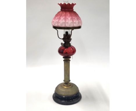 An oil lamp with chimney and pink overlay glass shade, 52cm.