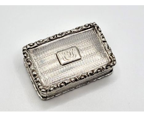 A monogramed silver snuff box with an internal hinged pierced work and engine turned base. Edward Smith, Birmingham (dates wo