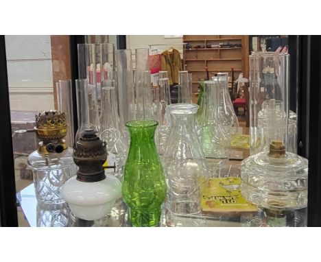 Fifteen glass oil lamp chimneys and three oil lamp bases. (18)