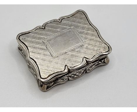 A silver snuff box with internal hinge pierced work, machine turned on the base and engraved around, and a blank plaque. Edwa