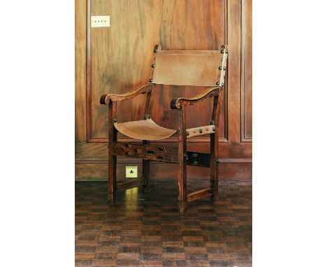 A 17th-century style leather slung open armchair, with pierced and carved front seat rail, 106 cm high x 62 cm wide, the seat