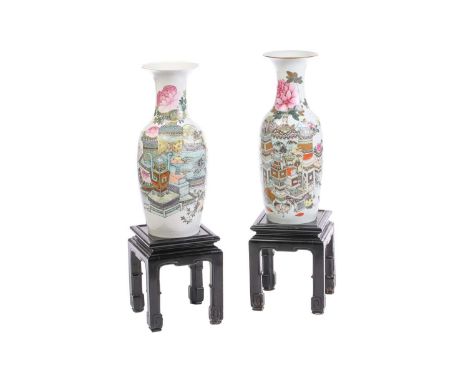 A pair of Chinese famille rose baluster vases, depicting vases of chrysanthemums, books, bowls of fruit and pictures, inscrib