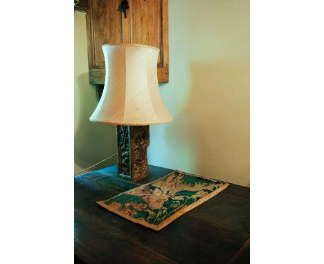 Antique carved plinth, converted to a table lamp base, 73 cm high with shade, together with a 17th-century tapestry fragment 