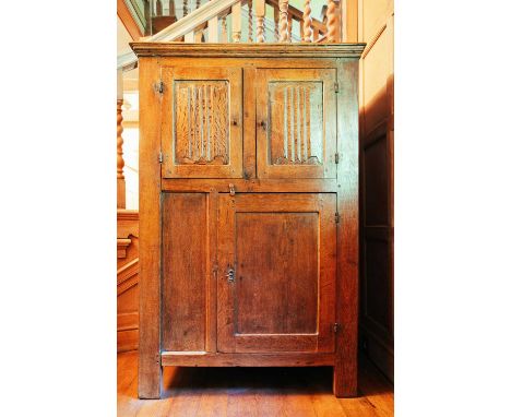 A 19th-century French oak two-door cupboard, the moulded cornice above a panelled door over a further door, on moulded bracke