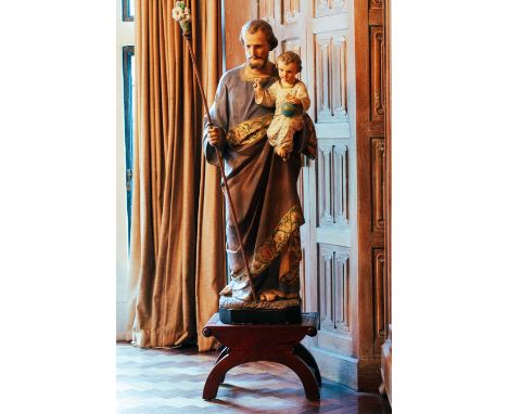 A polychrome painted and parcel gilt ceramic standing figure of St Joseph and the infant Christ, 126 cm highNB: Stand shown i