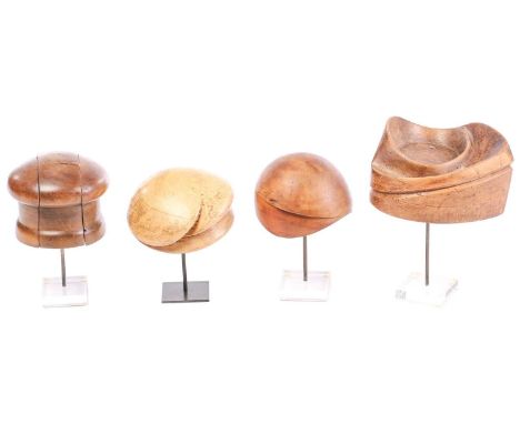 Four hardwood vintage hat lasts, of varying shapes, on display stands, tallest 34.5 cm on the standQty: 4