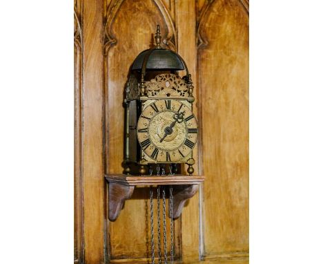 A late 17th century brass lantern clock, unsigned, the strapped bell over acorn finials, dolphin frets, tulip engraved centra