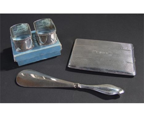 Mixed silver, to include a shoe horn, an engine turned cigarette case, and a boxed pair of napkin rings, (4)