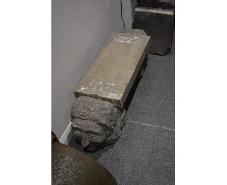 A stone bench with two gargoyle head supports, 100cm across, 33cm high