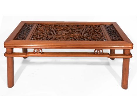 A Chinese elm coffee table with pierced and carved central panel with lions, pine trees and blossom with inset glass top, 125