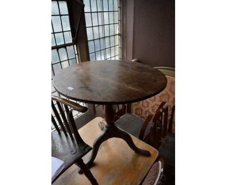 A George III oak tilt top table with circular top on tripod base