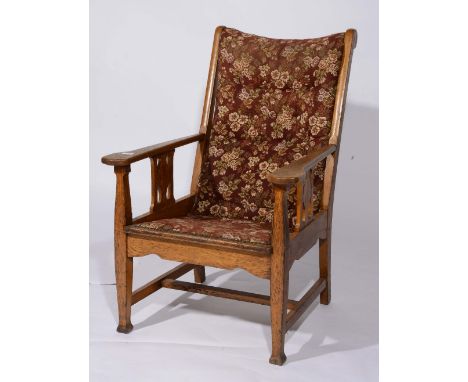An Arts & Crafts oak armchair possibly Heals with button back