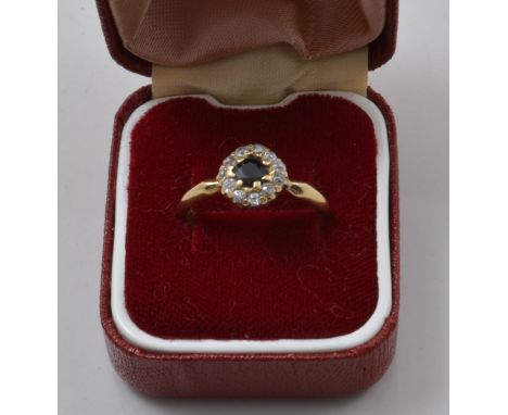 18ct sapphire and diamond cluster ring, with a single sapphire and eleven diamonds.
